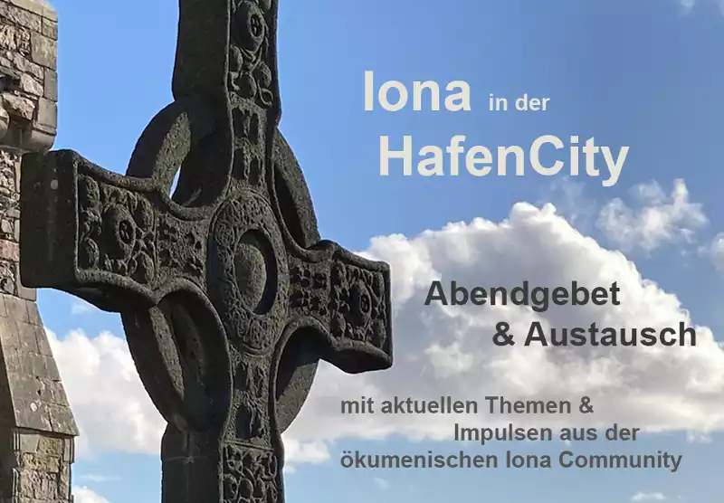 Ein keltisches Kreuz aus Stein vor dem blauen Himmel mit weißen Wolken